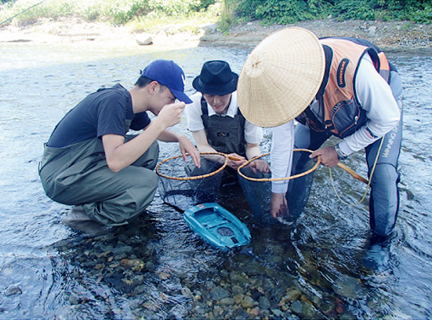 図4　入間漁協組合員（右）からおとりの扱い方を教わる学生（2018年6月30日）